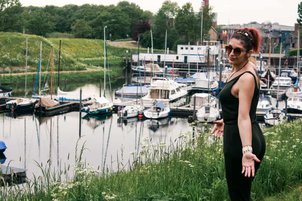 How to travel as a student: A girl taking a weekend trip to a small authentic village in The Netherlands. Villagers' fishing boats in the flowing canals of Holland