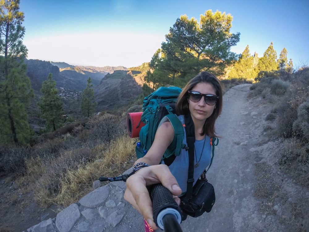 Tips on how to travel as a student: A girl camping alone overnight, taking a morning walk in the mountains in Gran Canaria, Spain