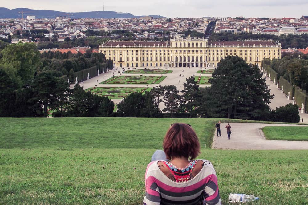 A girl relaxing on the large grass fields in front of the Schonbrunn palace in Vienna, Austria