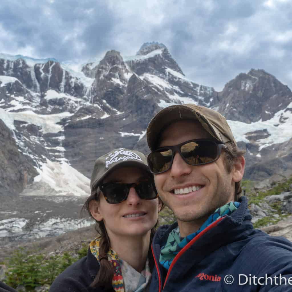 A couple's selfie in front of Torres del Paine Trek snowy mountains