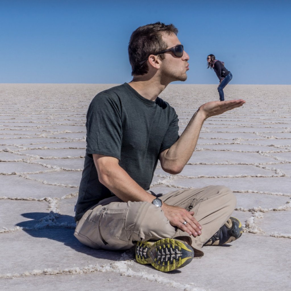 A big man holding and kissing a tiny woman in his hand in the salt lakes