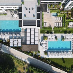 Drone photo of Therma Numera's 3 outdoor pools and chill out zone, leading to a booking affiliate link