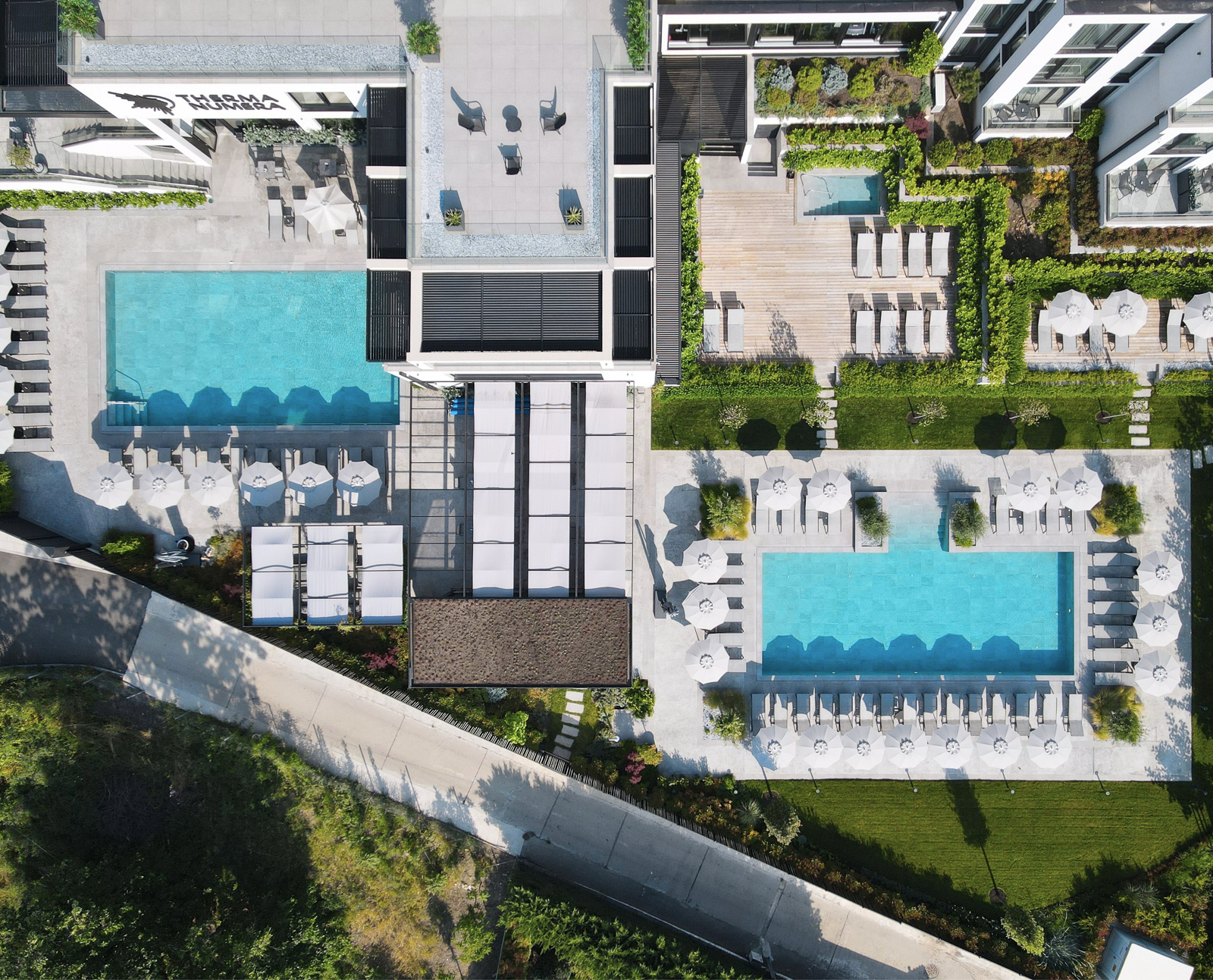 Drone photo of Therma Numera's 3 outdoor pools and chill out zone, leading to a booking affiliate link