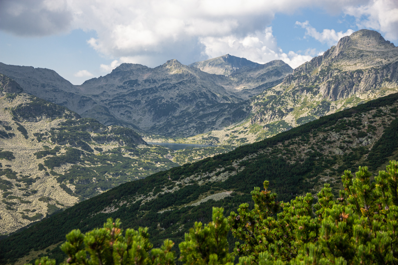 A view of Pirin National Park with a lake in the middle and rocky cliffs around