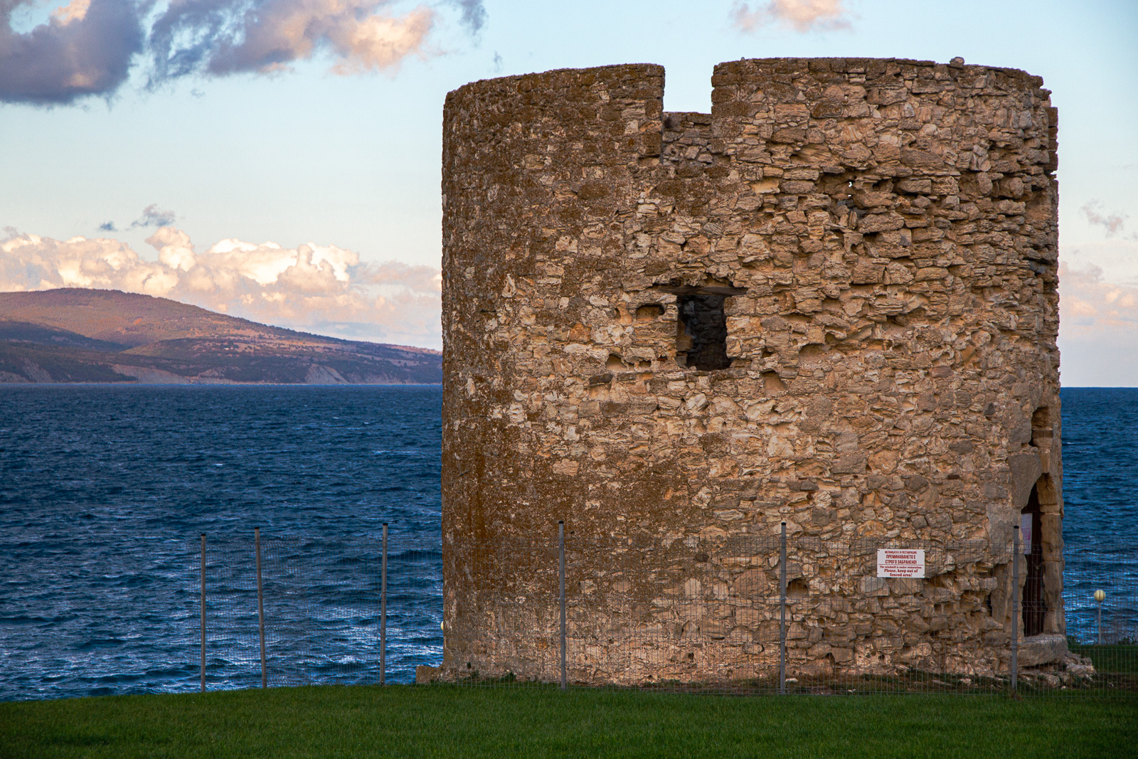 the old stone windmill with the sea in the background