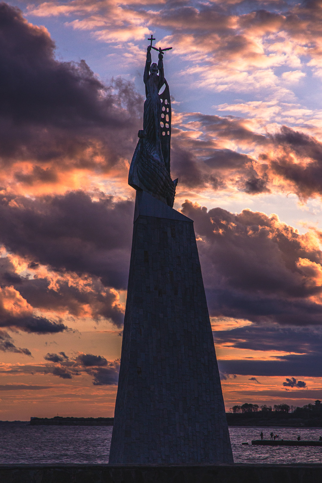 statue of a fisherman during sunset