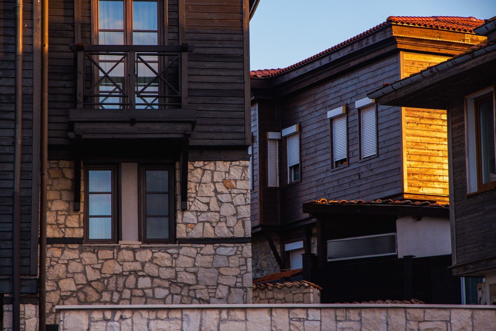 wood and stone black sea style houses during sunset - the image leads to an affiliate link
