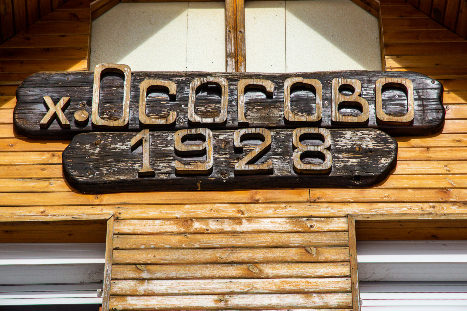 Osogovo hut name and year of creation carved on a wooden sign