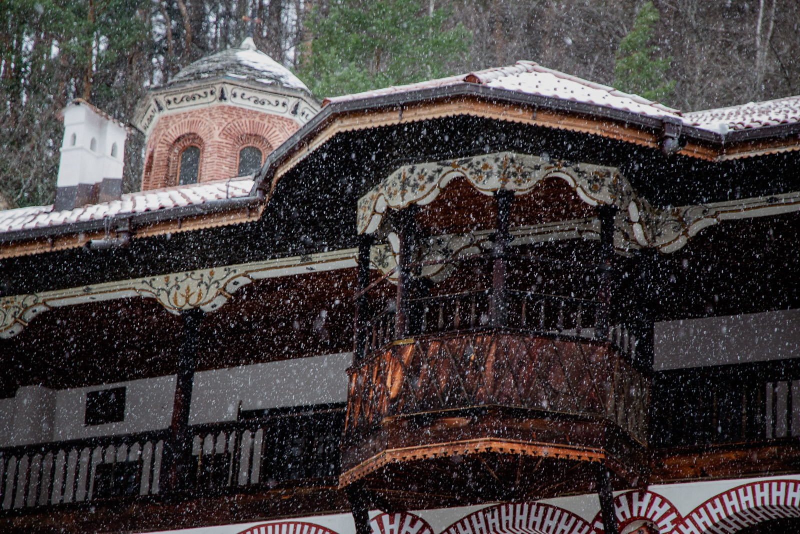 Snow falling on ornate architecture