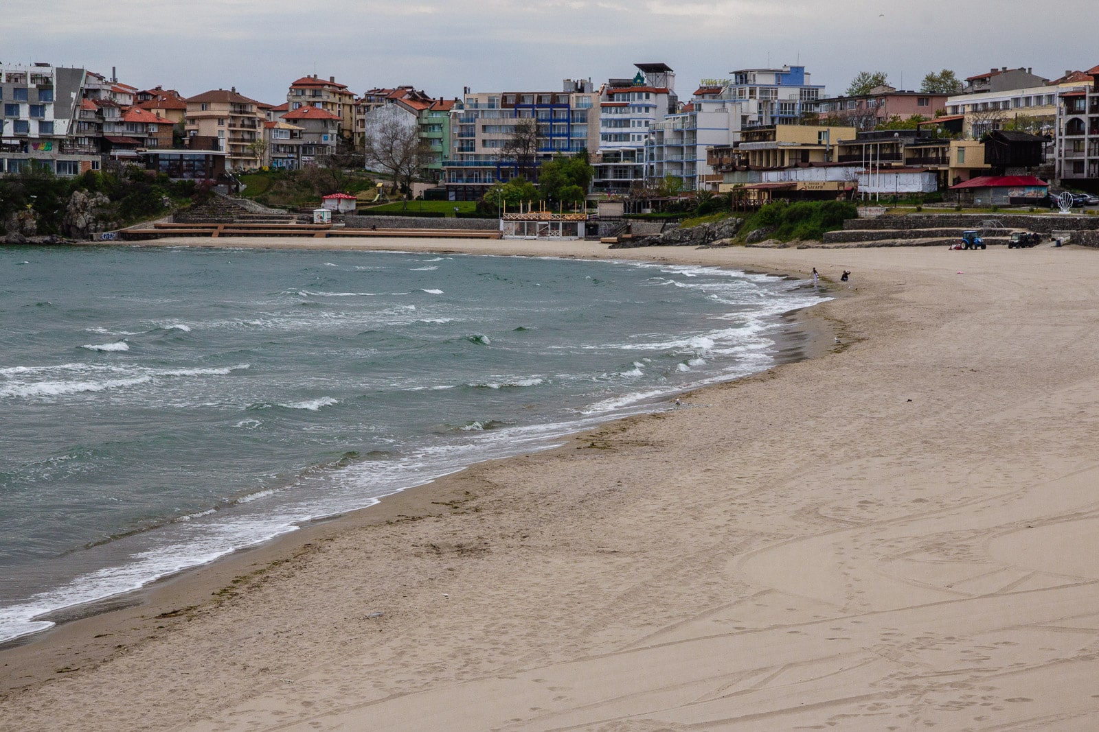 A tranquil beach with gentle waves, bordered by golden sand.