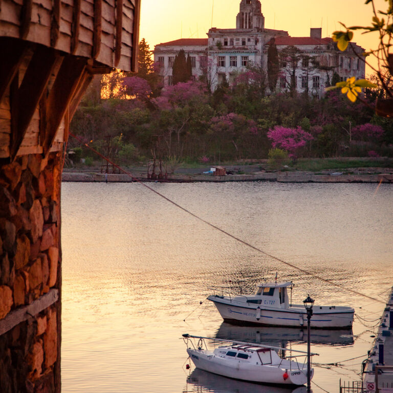 boats and a lovely old building on an island during sunset