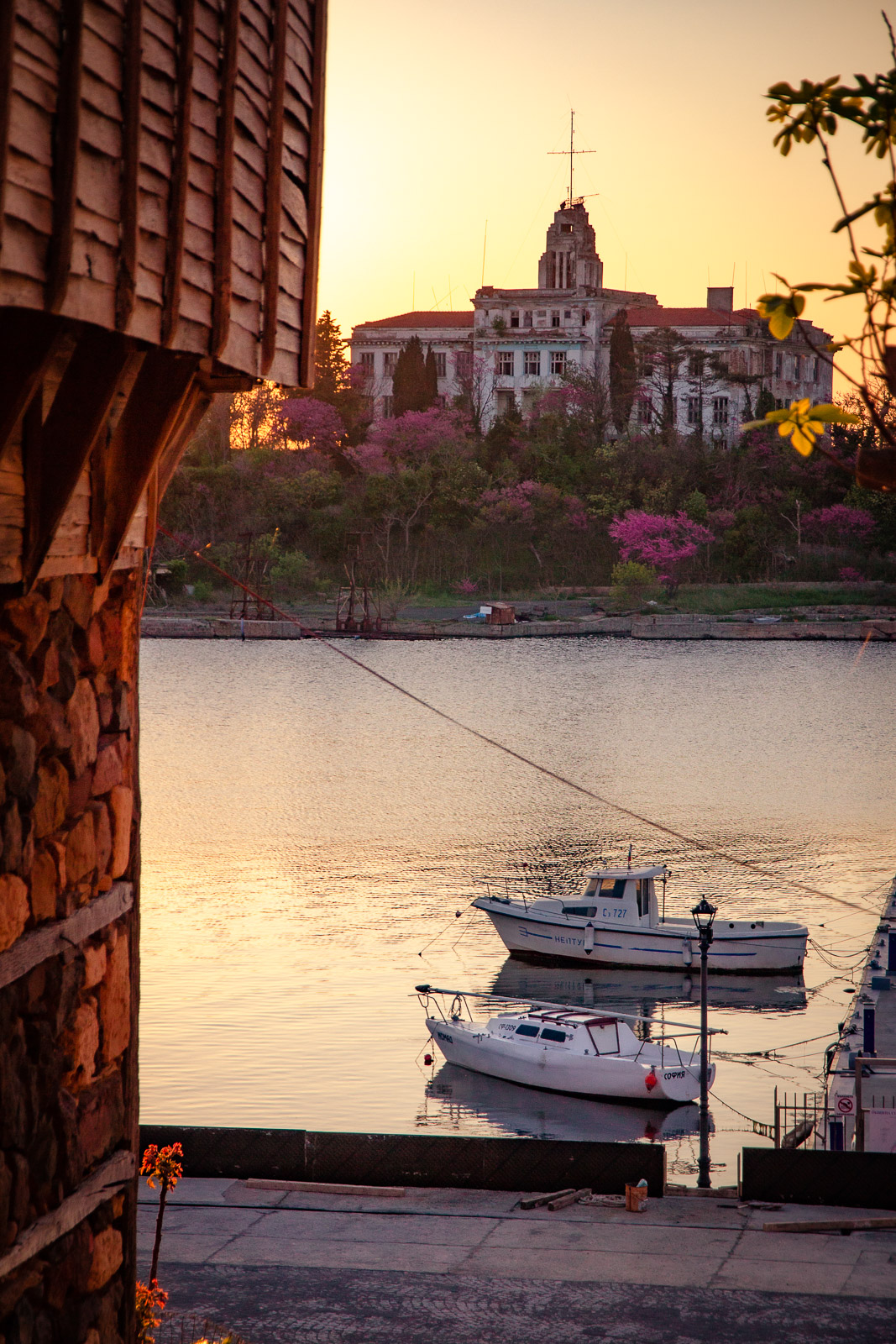 boats and a lovely old building on an island during sunset