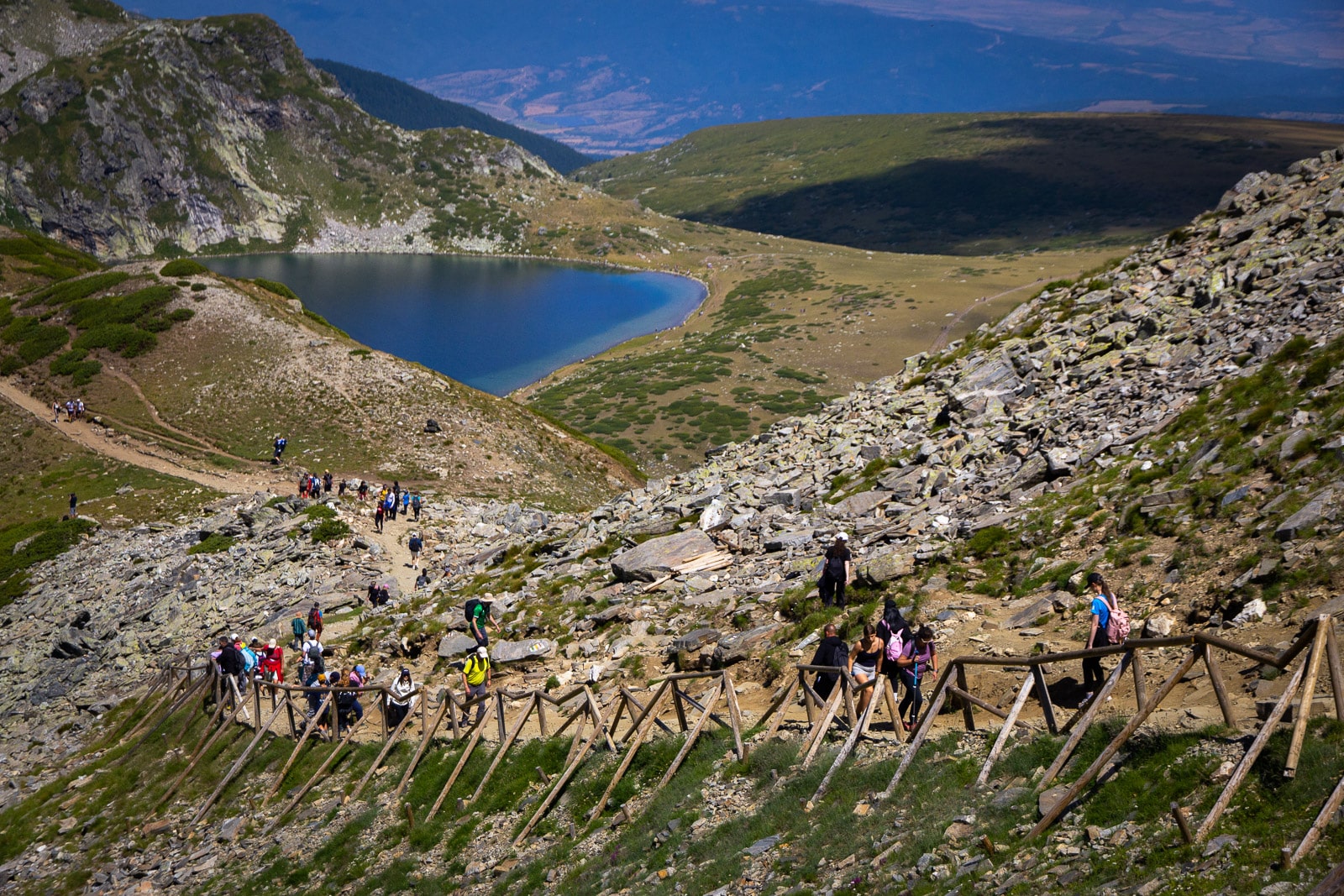 Mountain view with people hiking, a glacial lake and panorama